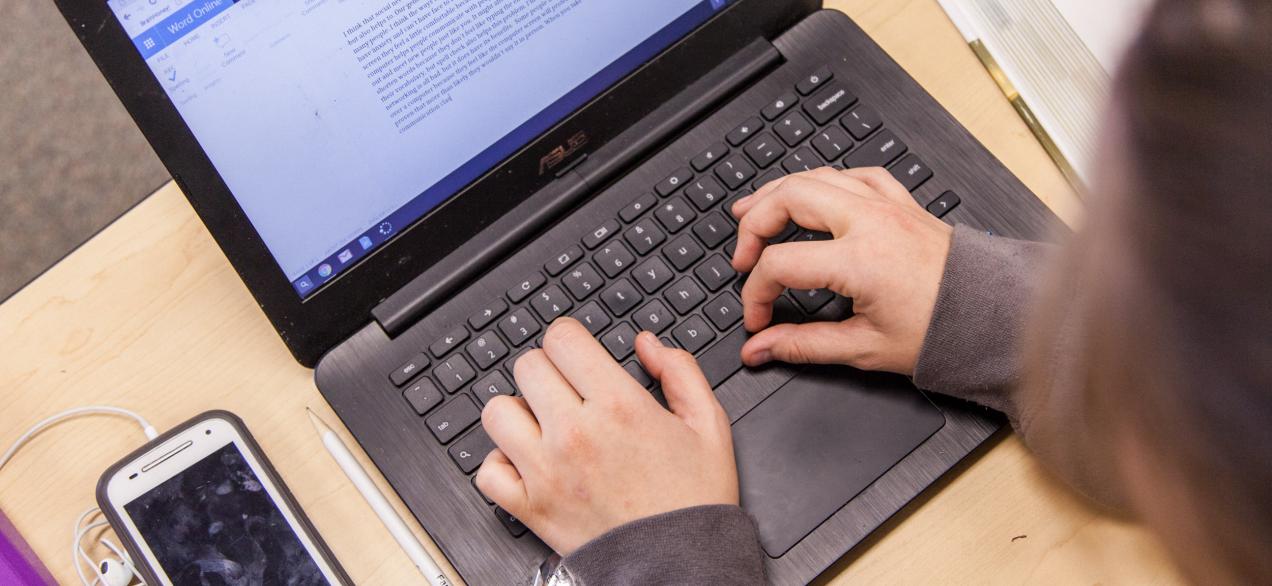 student typing on computer