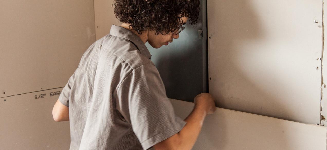 Image of student installing drywall