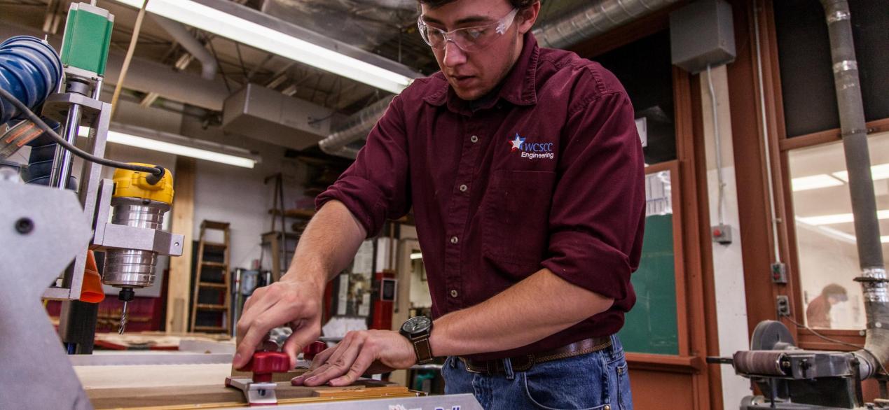 Image of student working on a machine to create a project