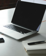 image of a laptop computer, notepad, and pen